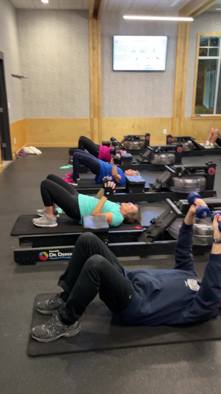 Group class doing dumbbell chest press