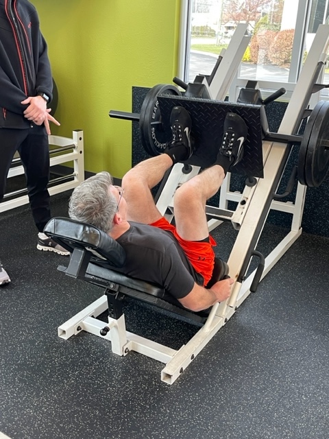 Client pushing weight on leg press