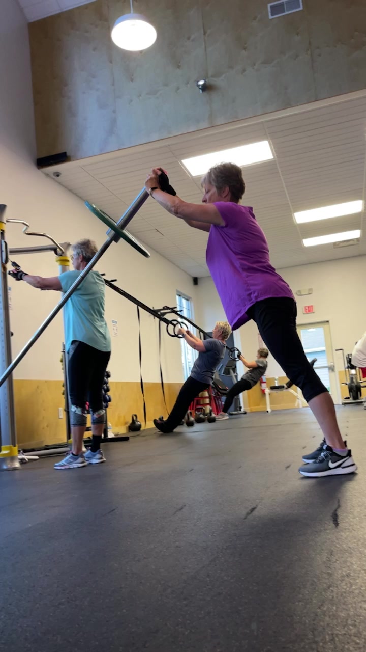 Three women doing TRX suspension exercises